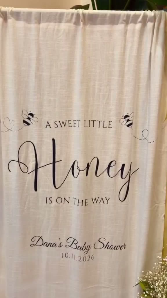 Linen baby shower backdrop with heat-pressed black lettering and bees